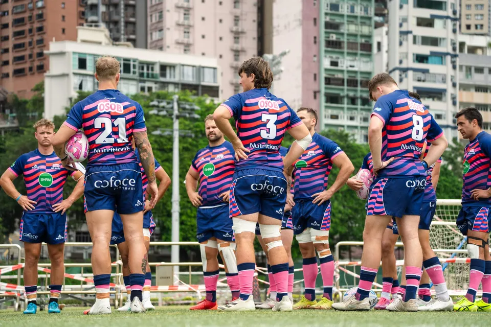 OSOB players warm up on the pitch at Happy Valley
