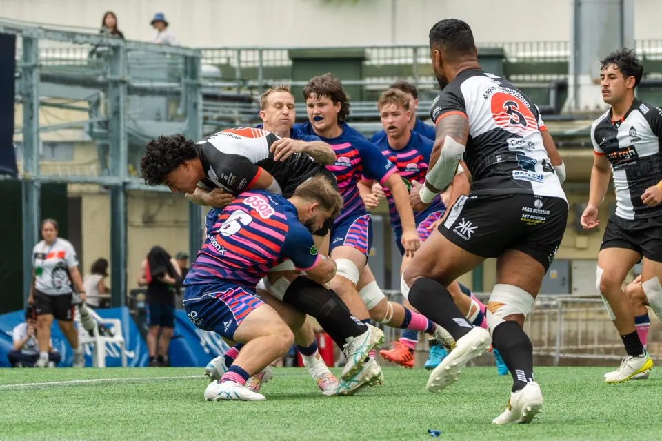 An OSOB player is tackled by two defenders