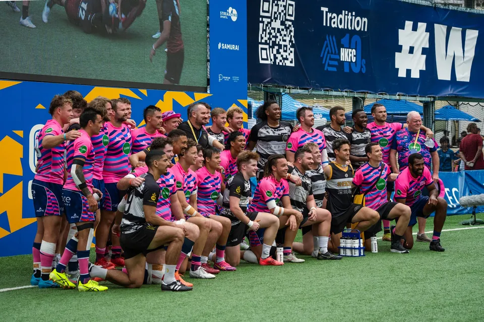 The OSOB squad gathers in front of the HKFC 10s scoreboard