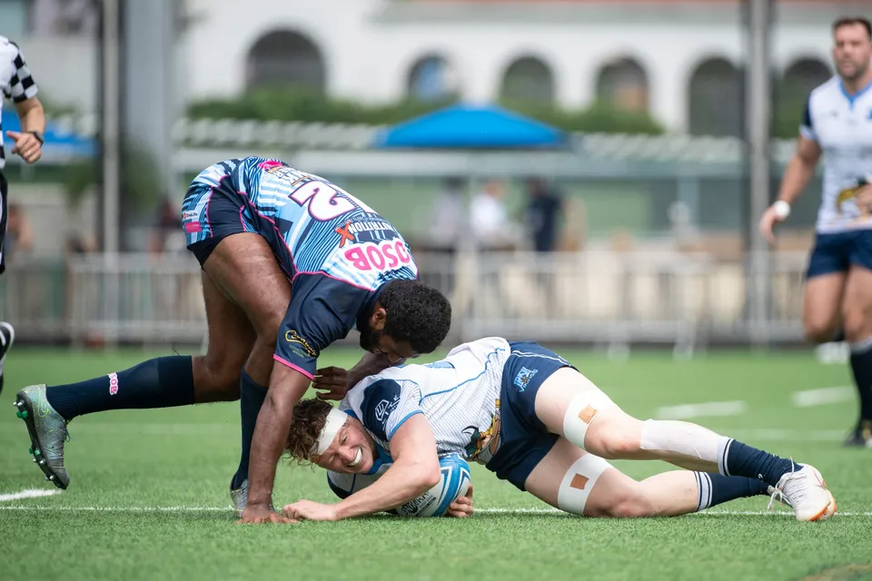 OSOB defender tackles a white-shirted Irish Vikings player as he stretches to the turf with the ball, 2019