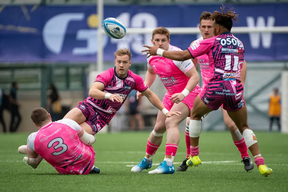 OSOB number 11 stretches an arm out as the ball flies past, a fallen Waterboys number 3 beside him