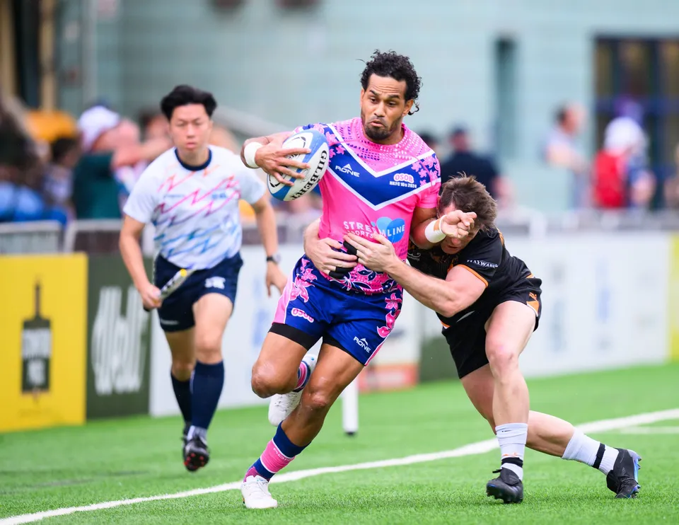 OSOB ball carrier is grabbed around the waist by an Ashbury Tropics defender while a teammate runs in support
