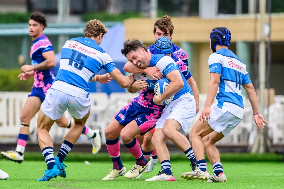 HKFC Natixis numbers 15 and 11 support their ball carrier as OSOB players converge in a tight contact