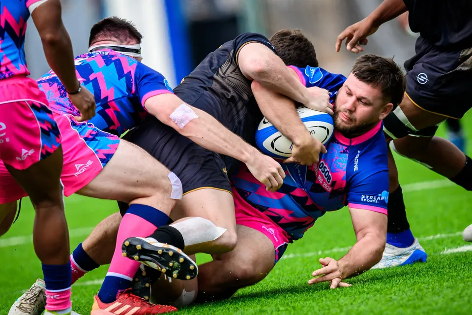 Bearded OSOB ball carrier is dragged to ground by Ashbury Tropics players in black in the 2026 HKFC 10s
