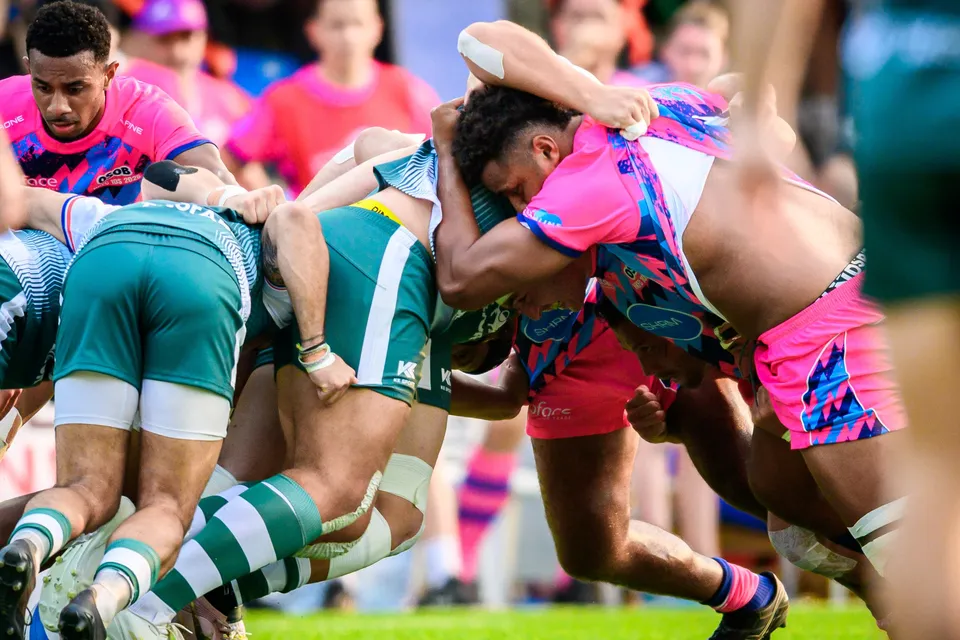Close-up of a tight scrum with OSOB and Froggies Club forwards locked together, shown from a low angle