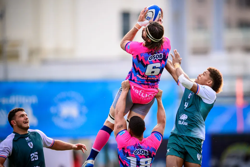 OSOB number 6 is lifted high by a teammate to take the line-out ball, a Froggies Club player reaching beside him
