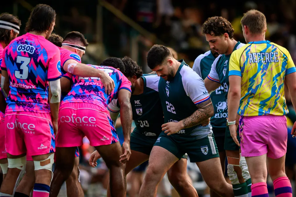 OSOB players and Froggies Club forwards gather in a loose huddle next to the yellow-shirted referee before a restart