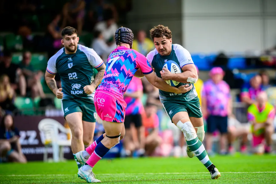 OSOB number 7 in a scrum cap closes on a Froggies Club ball carrier as a teammate runs in support