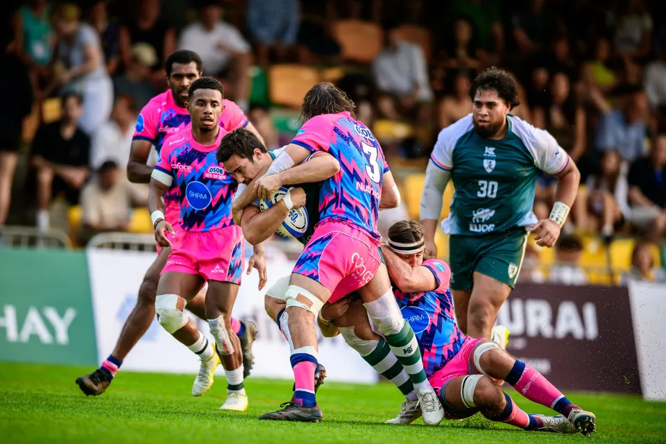 OSOB players tackle a Froggies Club ball carrier in the middle of the pitch while a teammate in green stands by
