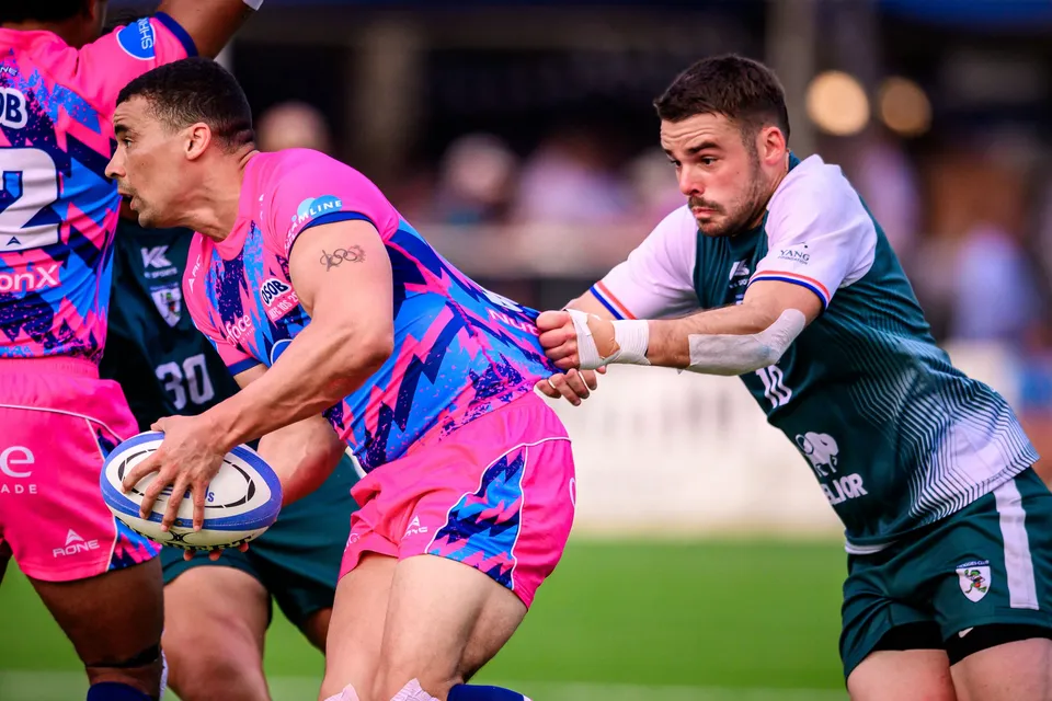 Close-up of an OSOB player passing the ball while a Froggies Club defender with a strapped wrist reaches for him