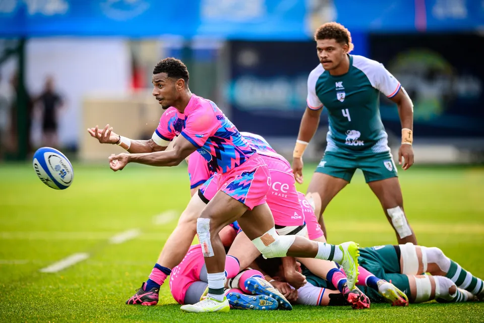 OSOB scrum-half in pink and blue passes from a ruck as a Froggies Club player in green looks on