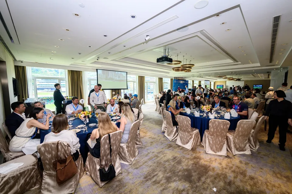 Wide view of guests seated at round tables with blue cloths in a function room, Patrons' Lunch, 2026 HKFC 10s