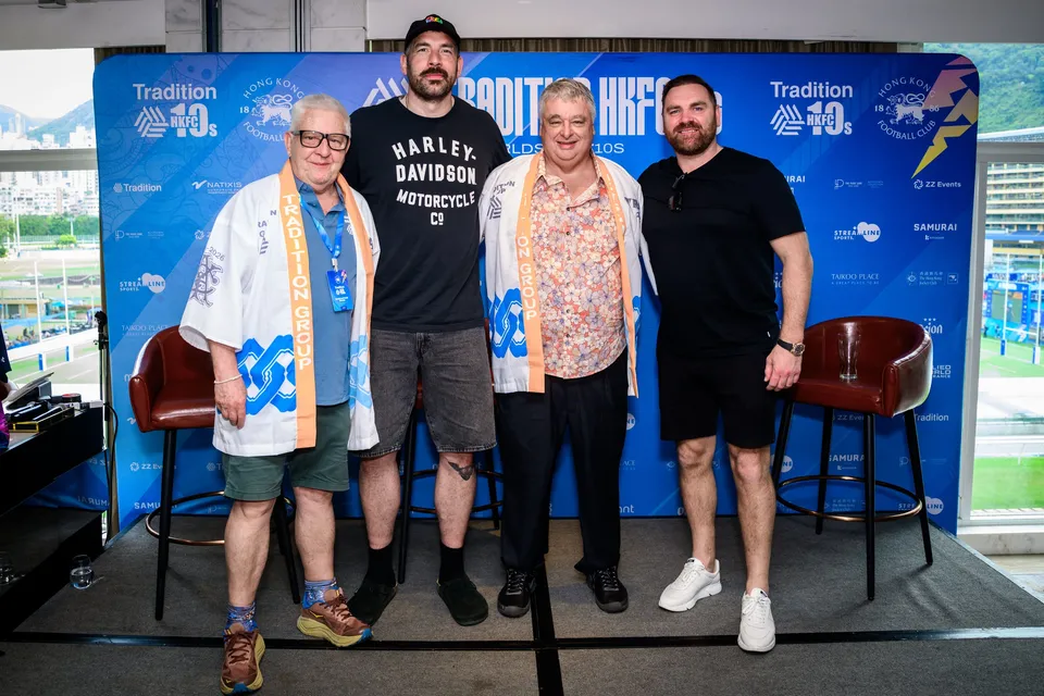 Four men pose in front of the HKFC 10s sponsor backdrop beside two red leather stools, 2026 press conference