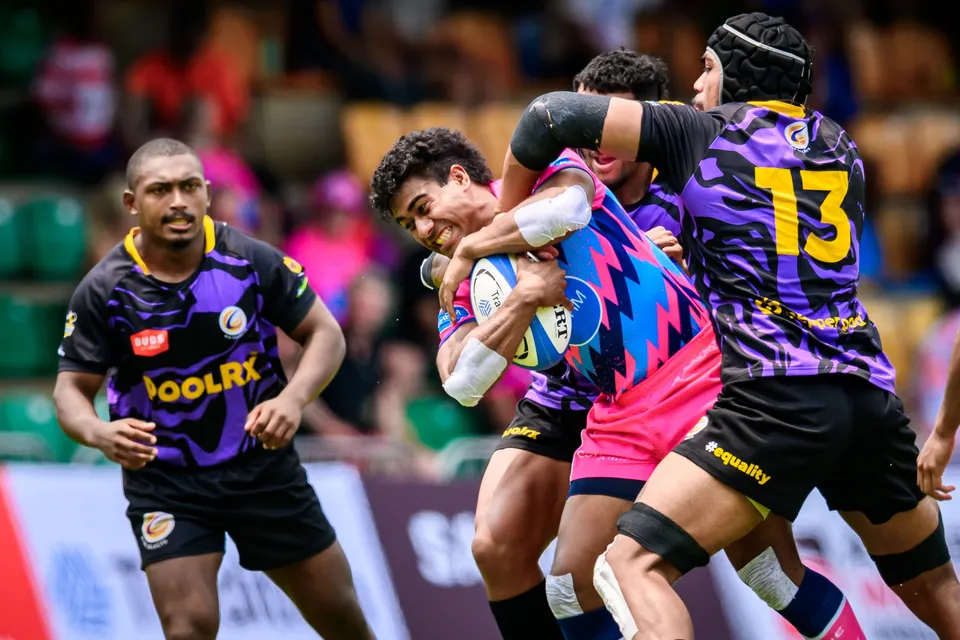 OSOB ball carrier is wrapped up by two Rugby Tens Selects defenders, one in a number 13 purple shirt