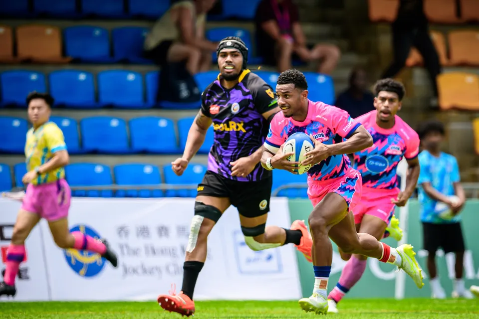 OSOB runner breaks clear with the ball under one arm along the touchline, a purple-kit defender in pursuit