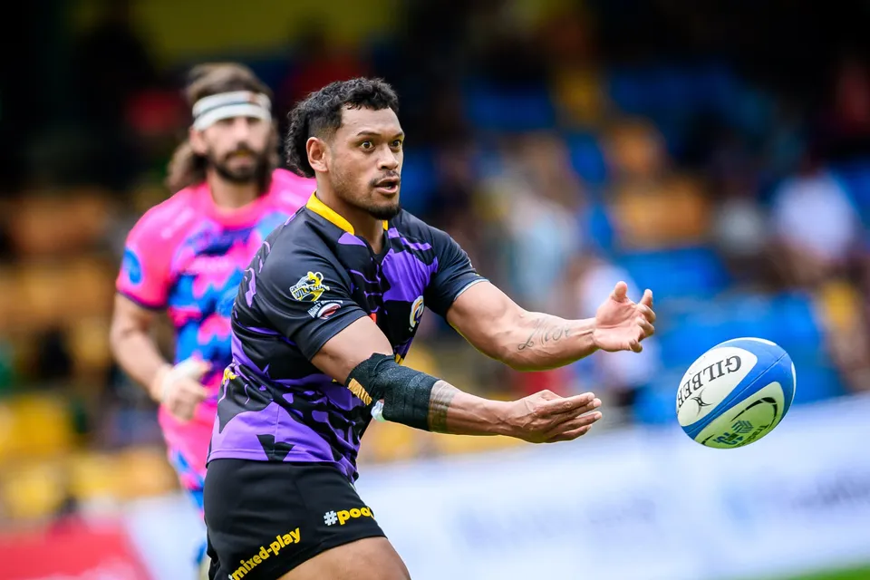 Tens Selects player in purple passes the ball one-handed as a headbanded OSOB player looks on behind him