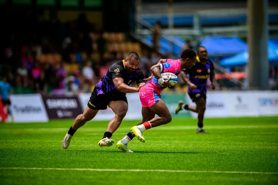 OSOB ball carrier is hauled in by a large Tens Selects defender while another purple player runs up behind