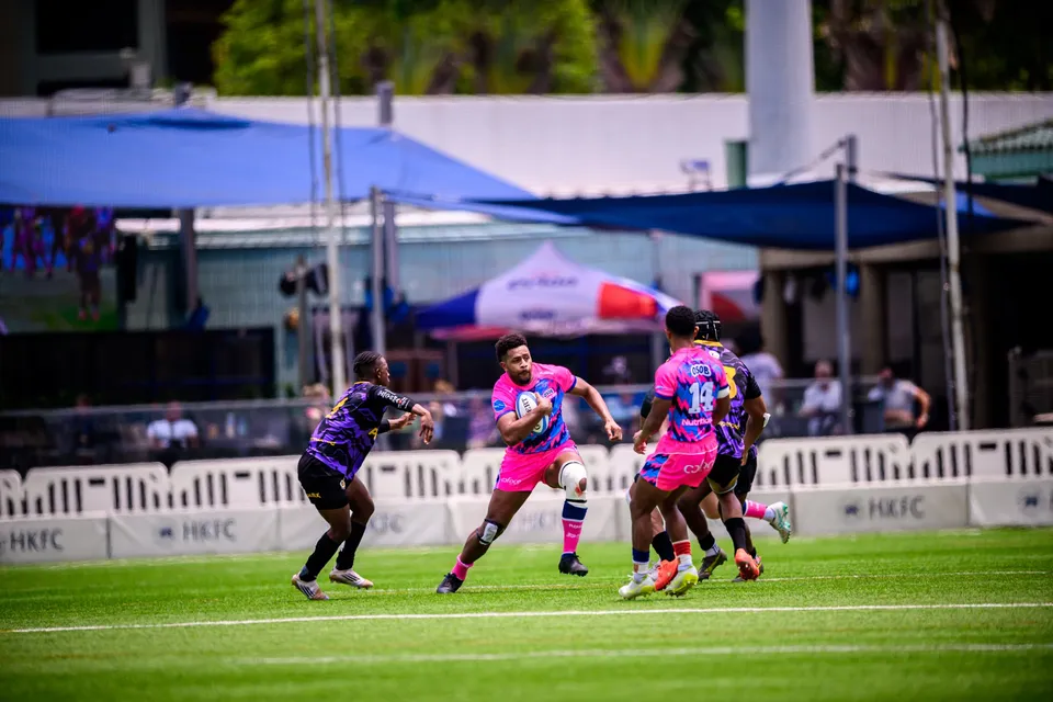 Wide view of an OSOB player running with the ball, teammates alongside and a Tens Selects defender at left