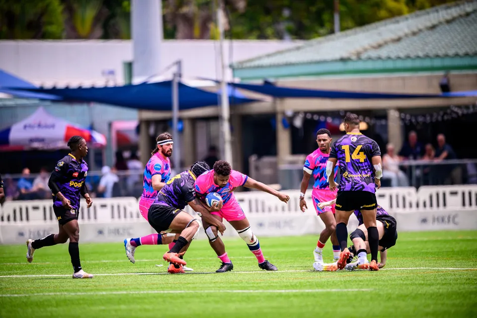 Wide view of an OSOB player carrying the ball into contact with Tens Selects number 14 and others, tents behind