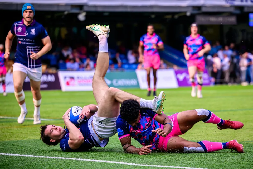 Players from both sides tangle on the grass close to the try line as the ball is held against the turf