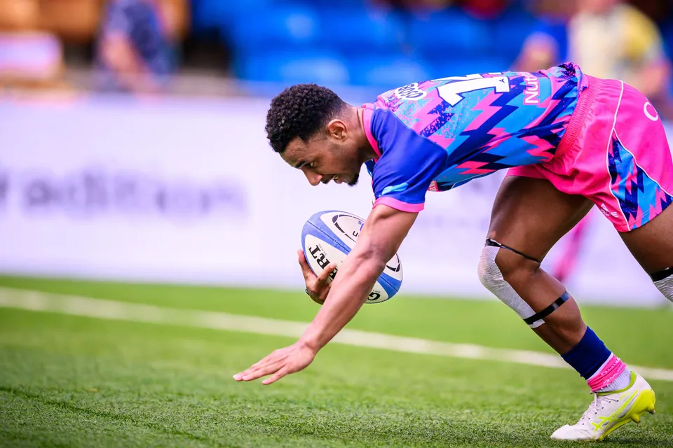 OSOB player stretches low to ground the ball over the line in a close-up shot on the grass pitch