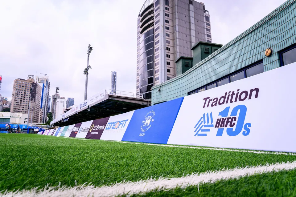 Stand with blue and orange seats behind Taikoo Place, Streamline Sports and Tradition boards, Natixis banner above