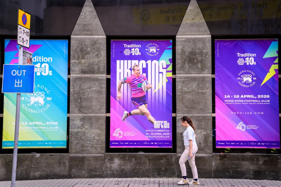 Three tournament posters on a stone wall, with a player in pink and blue on the left and another on the right
