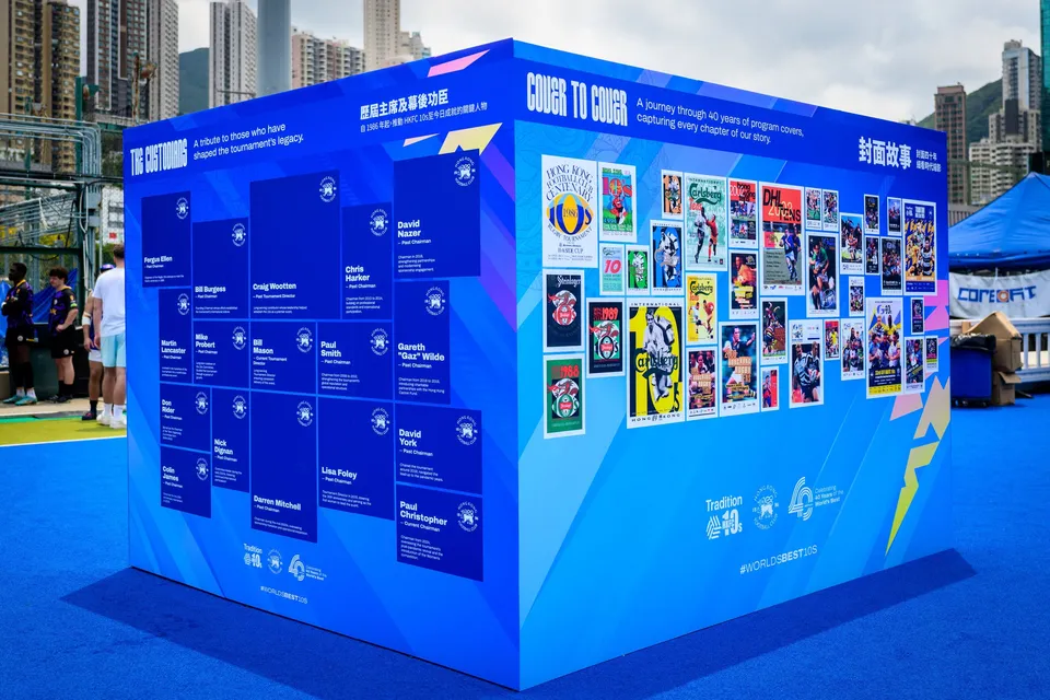Corner of a blue Cover to Cover display box showing programme covers and a list of names, people at left